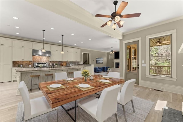 dining room with recessed lighting, ceiling fan, ornamental molding, and light wood finished floors