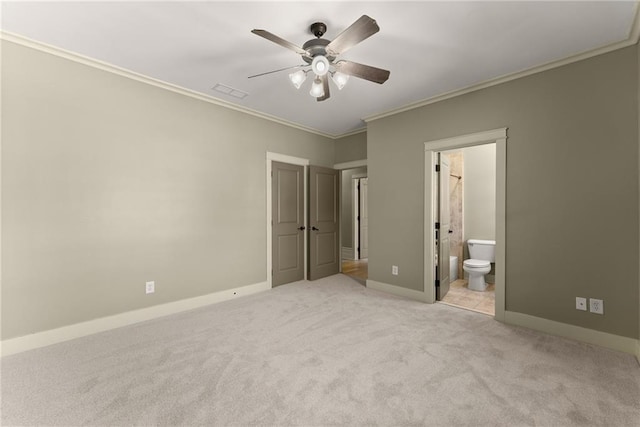 unfurnished bedroom featuring visible vents, baseboards, ornamental molding, light carpet, and ensuite bath