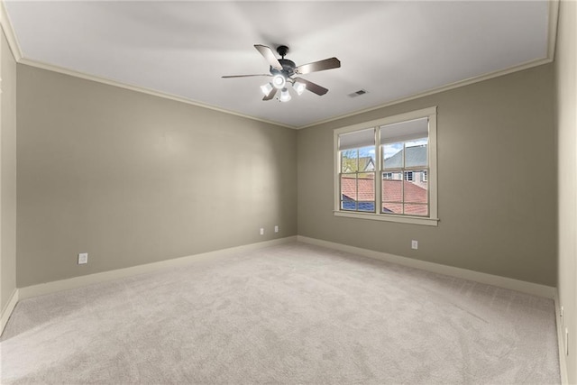 empty room with crown molding, carpet floors, a ceiling fan, and visible vents