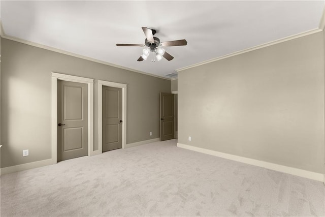 unfurnished bedroom with carpet floors, baseboards, crown molding, and ceiling fan