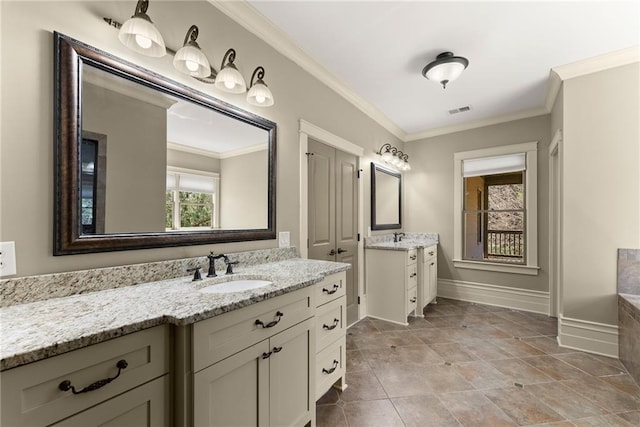 bathroom with visible vents, crown molding, baseboards, two vanities, and a sink