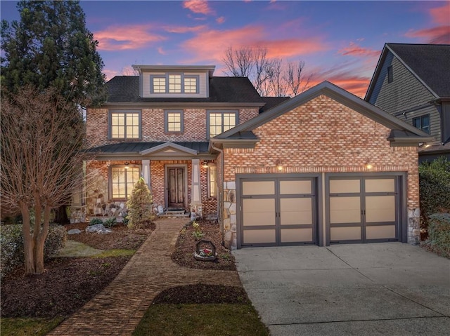 view of front of property with concrete driveway, brick siding, an attached garage, and stone siding