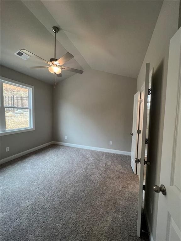 carpeted spare room with vaulted ceiling and ceiling fan