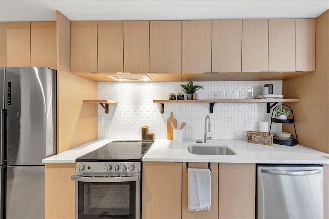 kitchen with appliances with stainless steel finishes, light brown cabinetry, sink, and backsplash