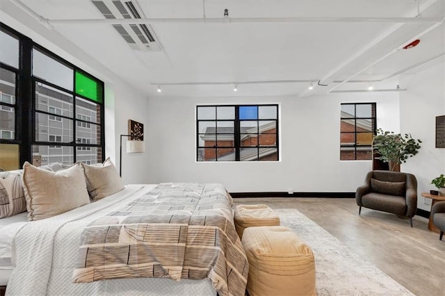 bedroom featuring concrete flooring and multiple windows