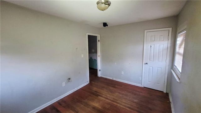 unfurnished bedroom with dark wood-type flooring and a closet