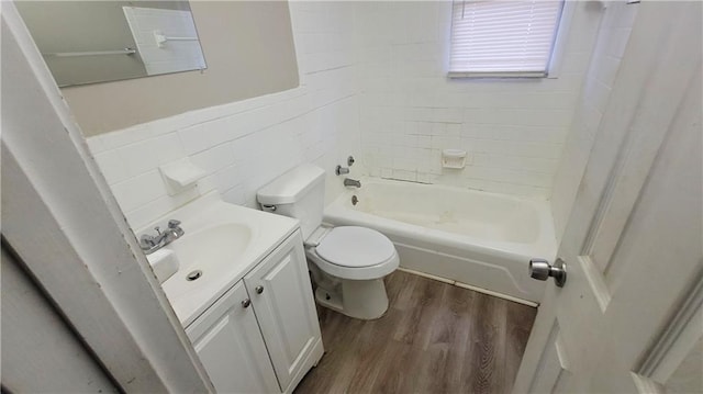 full bathroom with tiled shower / bath, wood-type flooring, toilet, and vanity