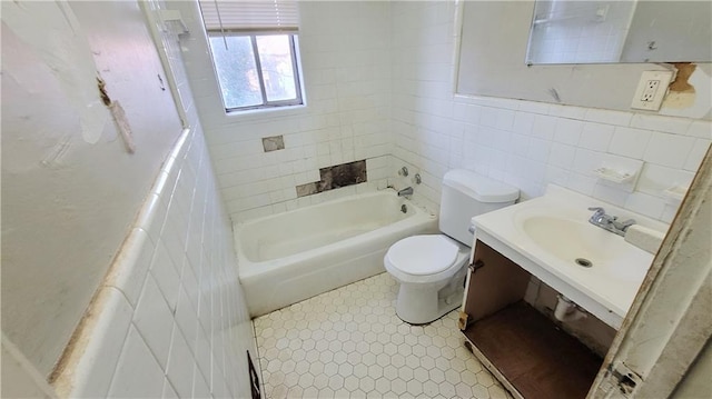 full bathroom featuring tiled shower / bath, toilet, sink, and tile walls