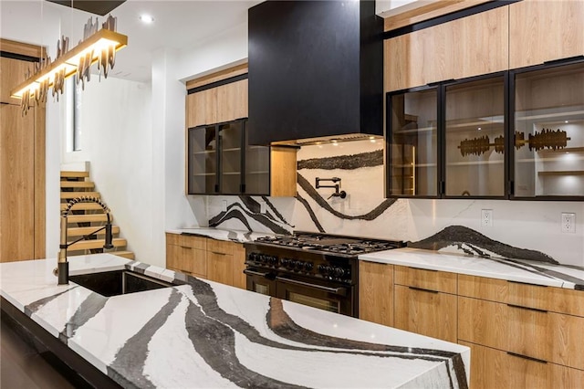 15154 Hopewell Rd, Alpharetta, GA 30004 - kitchen featuring range with two ovens, modern cabinets, light stone counters, glass insert cabinets, and a sink