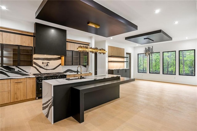 15154 Hopewell Rd, Alpharetta, GA 30004 - kitchen featuring range with gas cooktop, a sink, range hood, modern cabinets, and an island with sink