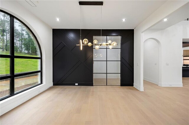 15154 Hopewell Rd, Alpharetta, GA 30004 - unfurnished dining area with healthy amount of natural light, baseboards, light wood-style floors, a chandelier, and a decorative wall