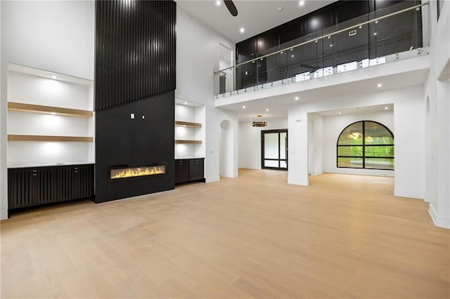 15154 Hopewell Rd, Alpharetta, GA 30004 - unfurnished living room featuring wood finished floors, a high ceiling, a fireplace, and baseboards