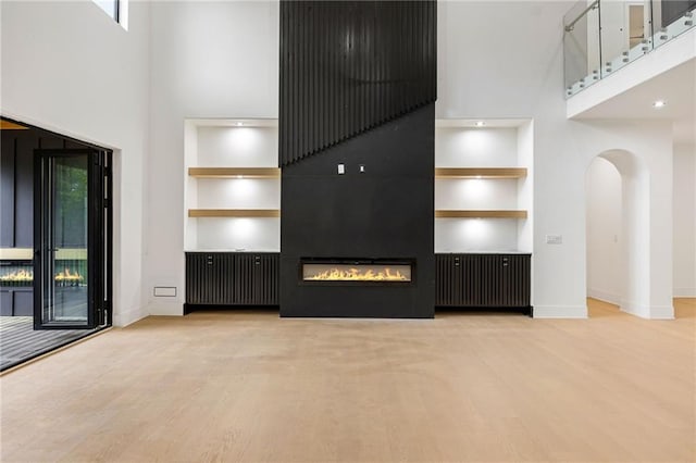 15154 Hopewell Rd, Alpharetta, GA 30004 - unfurnished living room with built in shelves, a towering ceiling, healthy amount of natural light, and baseboards