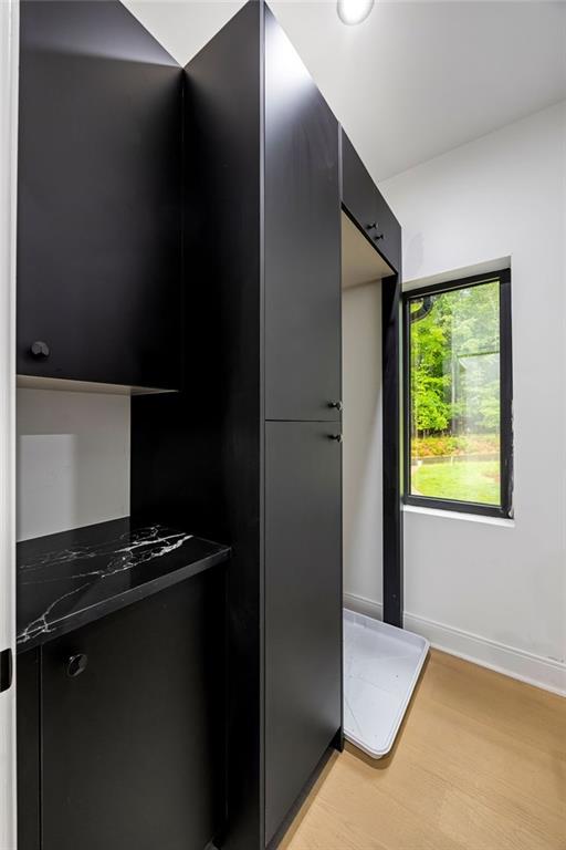 15154 Hopewell Rd, Alpharetta, GA 30004 - kitchen featuring dark cabinets, light wood-type flooring, modern cabinets, and baseboards
