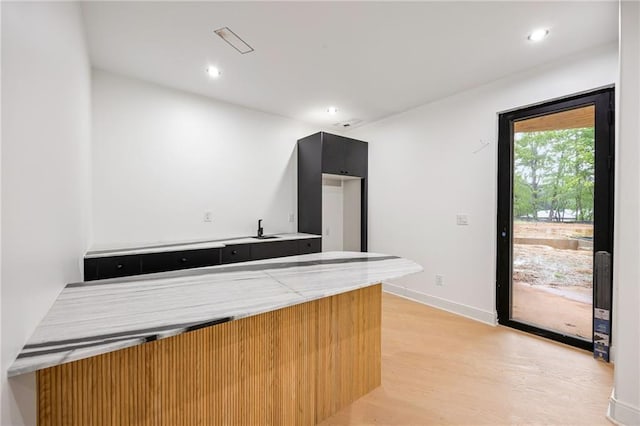 15154 Hopewell Rd, Alpharetta, GA 30004 - kitchen with light countertops, light wood-style flooring, dark cabinets, recessed lighting, and baseboards