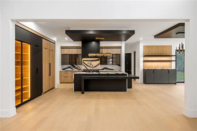 15154 Hopewell Rd, Alpharetta, GA 30004 - kitchen featuring light wood-type flooring, modern cabinets, a center island, baseboards, and a kitchen breakfast bar