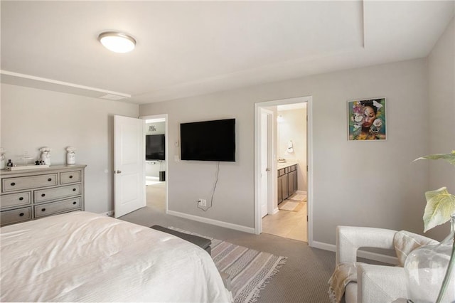 bedroom featuring light carpet and ensuite bathroom