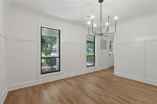 9165 Eves Cir, Roswell, GA 30076 - unfurnished dining area with a decorative wall, a chandelier, wood finished floors, healthy amount of natural light, and ornamental molding