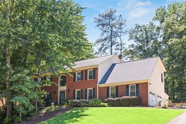 3837 Fenway Xing, Marietta, GA 30062 - colonial home featuring a front lawn, brick siding, an attached garage, driveway, and roof with shingles