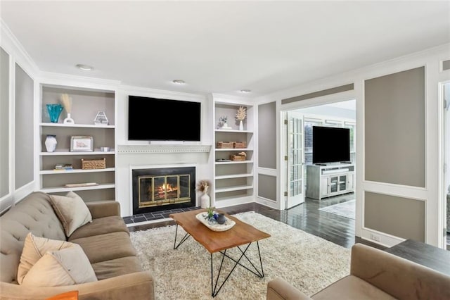 3837 Fenway Xing, Marietta, GA 30062 - living room featuring built in shelves, ornamental molding, a glass covered fireplace, dark wood finished floors, and baseboards