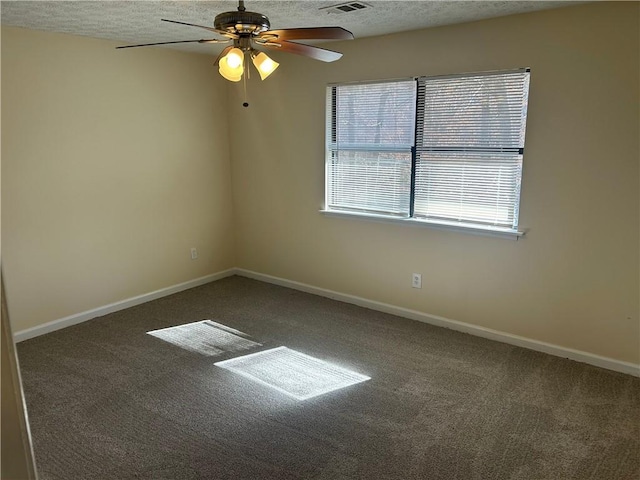 carpeted empty room featuring ceiling fan, plenty of natural light, and a textured ceiling