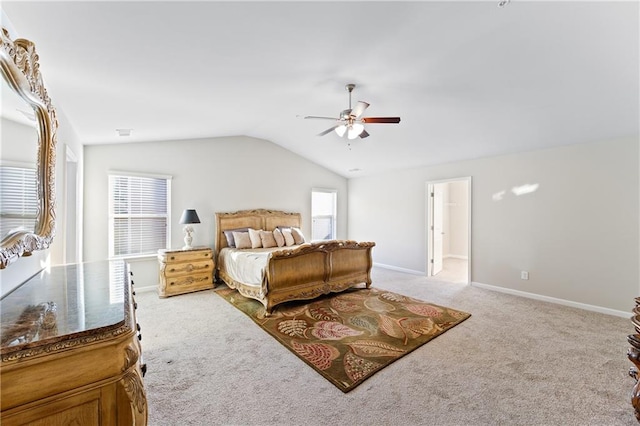 bedroom featuring connected bathroom, ceiling fan, light carpet, and lofted ceiling