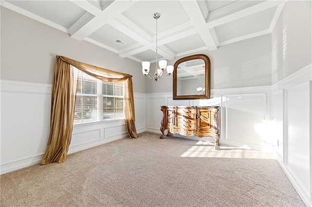 unfurnished dining area with coffered ceiling, beamed ceiling, a chandelier, carpet, and ornamental molding