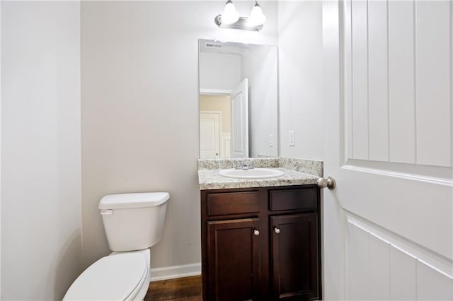 bathroom featuring vanity, wood-type flooring, and toilet