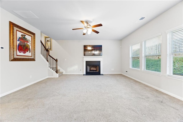 unfurnished living room featuring ceiling fan and light colored carpet