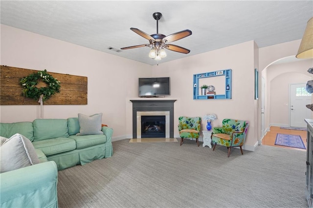 80 Riley Place Dr, Dawsonville, GA 30534 - living area featuring arched walkways, light colored carpet, ceiling fan, and a fireplace with flush hearth