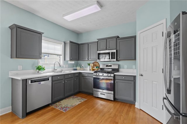 80 Riley Place Dr, Dawsonville, GA 30534 - kitchen with stainless steel appliances, gray cabinets, light wood-style floors, a textured ceiling, and light countertops
