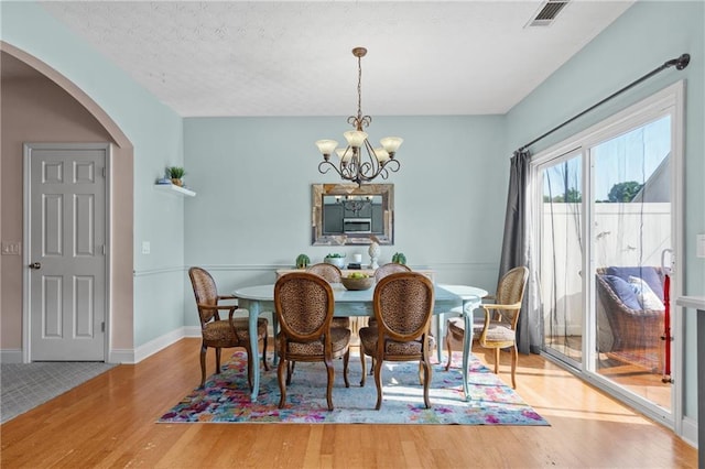 80 Riley Place Dr, Dawsonville, GA 30534 - dining space featuring wood finished floors, arched walkways, and a chandelier