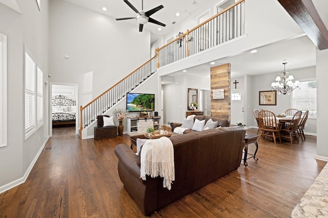 living area with stairway, ceiling fan with notable chandelier, baseboards, and wood finished floors