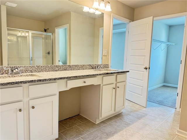 bathroom featuring vanity, a chandelier, a shower with shower door, and tile patterned flooring