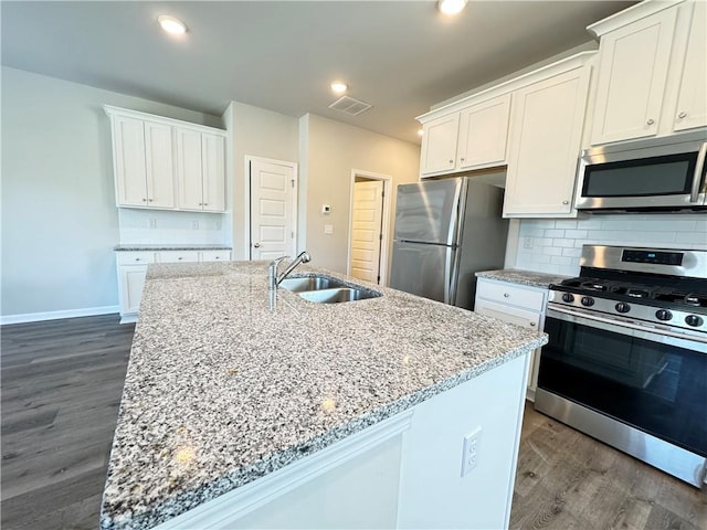 kitchen featuring a kitchen island with sink, dark hardwood / wood-style floors, stainless steel appliances, sink, and white cabinetry