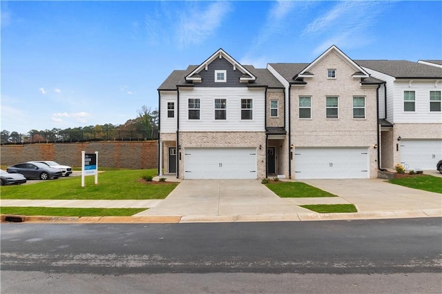 view of property with a garage, concrete driveway, a front lawn, and brick siding