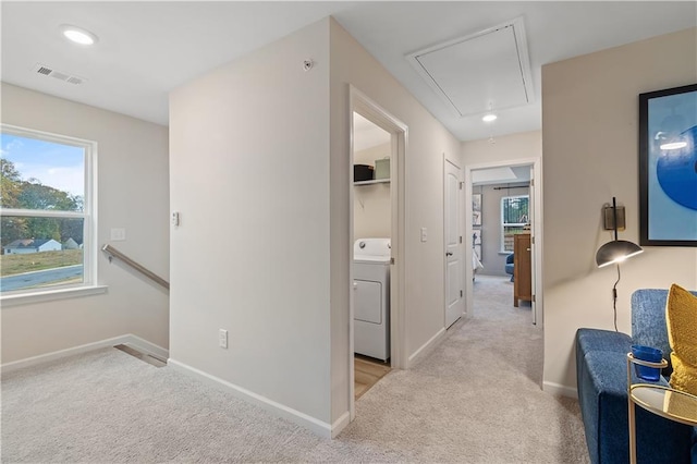 corridor with washer / dryer, attic access, visible vents, and carpet floors