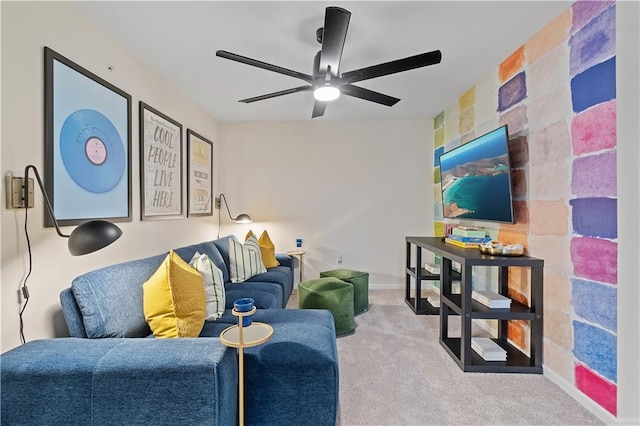 carpeted living room with baseboards and a ceiling fan