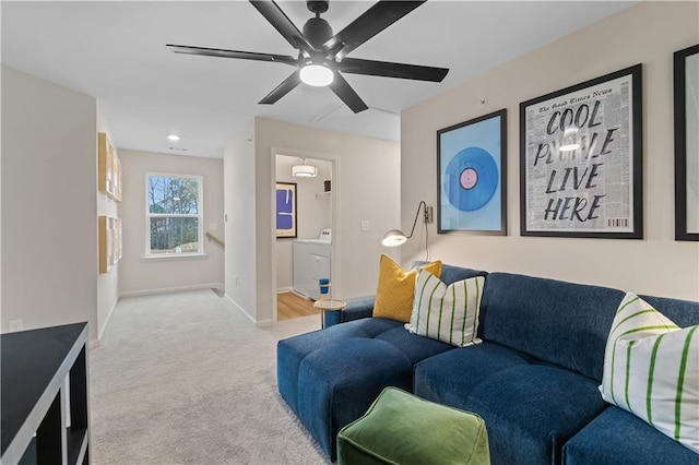 carpeted living area featuring baseboards, washer / clothes dryer, and a ceiling fan