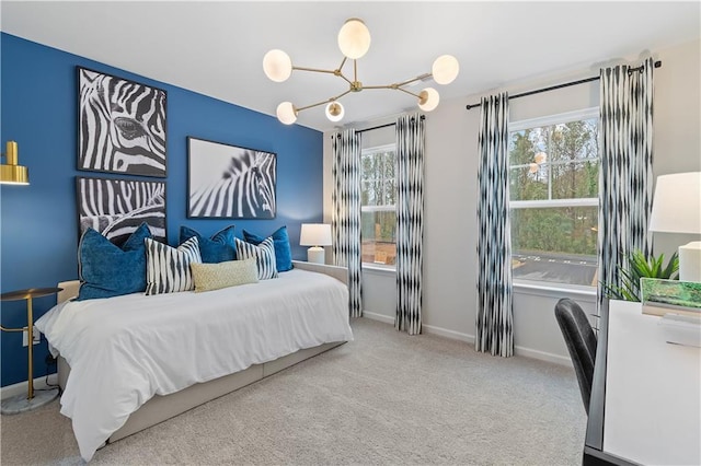 carpeted bedroom featuring multiple windows, baseboards, and a chandelier