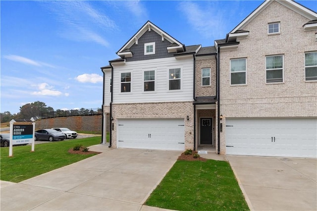 view of front of home featuring a garage, brick siding, driveway, and a front lawn