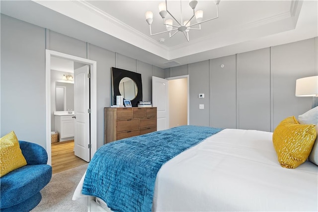 bedroom featuring a tray ceiling, a notable chandelier, and crown molding