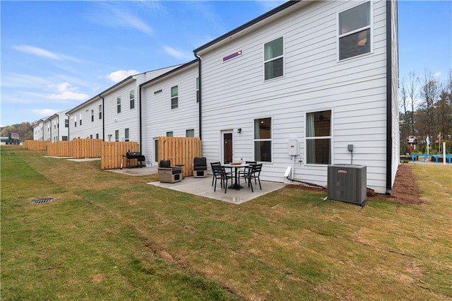 rear view of property featuring a patio, a yard, fence, and central air condition unit