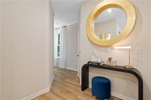 corridor featuring baseboards and wood finished floors