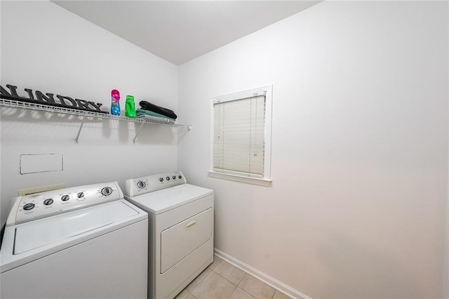 clothes washing area featuring light tile patterned floors and washer and clothes dryer