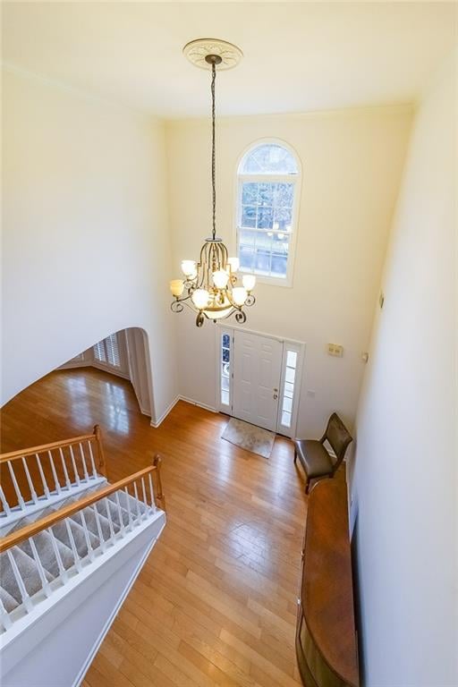 entrance foyer with hardwood / wood-style floors and a chandelier