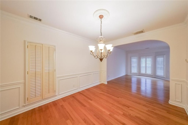 unfurnished dining area with a chandelier, hardwood / wood-style flooring, and crown molding