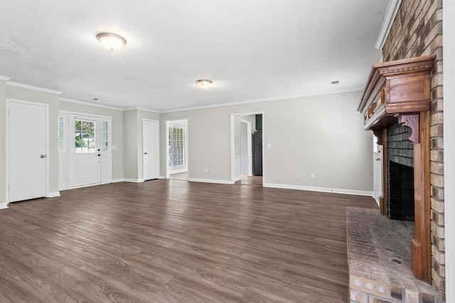 unfurnished living room featuring dark hardwood / wood-style flooring, ornamental molding, and a brick fireplace