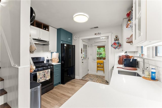 233 Spence Ave SE, Atlanta, GA 30317 - kitchen featuring gas range, under cabinet range hood, freestanding refrigerator, a sink, and light countertops