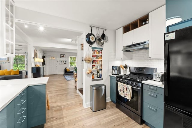 233 Spence Ave SE, Atlanta, GA 30317 - kitchen with freestanding refrigerator, under cabinet range hood, gas range oven, light wood-style flooring, and light countertops